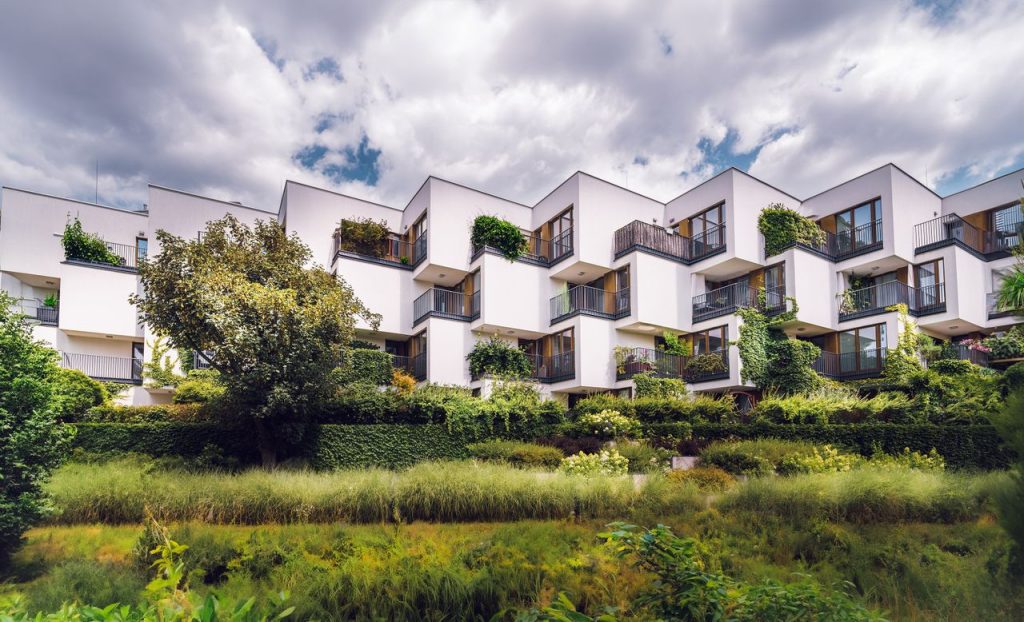 pexels photo 27992248 27992248 Contemporary apartment complex featuring sustainable architecture with lush greenery and open balconies.